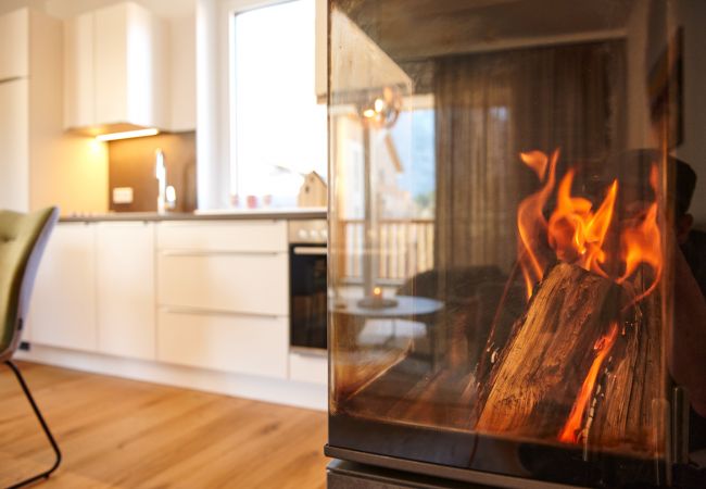 Fireplace with view over the kitchen in the holiday home Alm Lodge A5 in Tauplitz