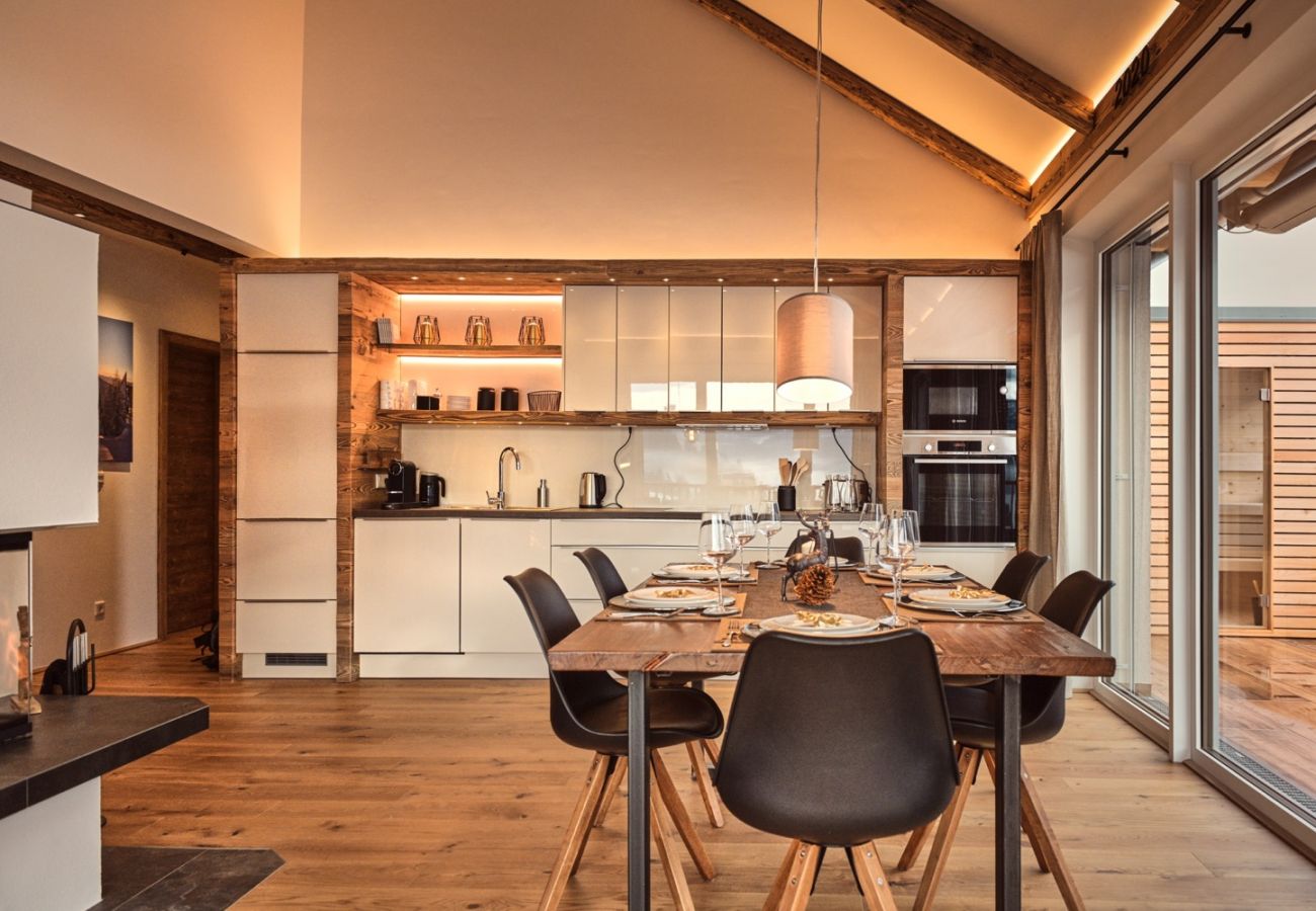 Kitchen with dining table in the holiday home flat Penthouse Grimming Adler Lodge D7.1 in Tauplitz