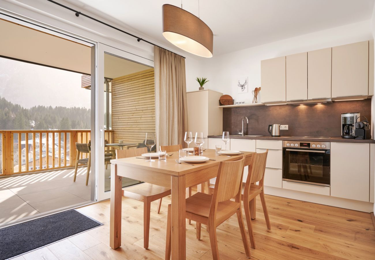 Kitchen with dining table in the holiday home flat Adler Lodge D1 in Tauplitz