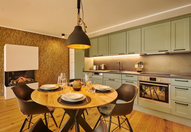 Kitchen with dining table in the holiday home flat Adler Auszeit Lodge D6 in Tauplitz