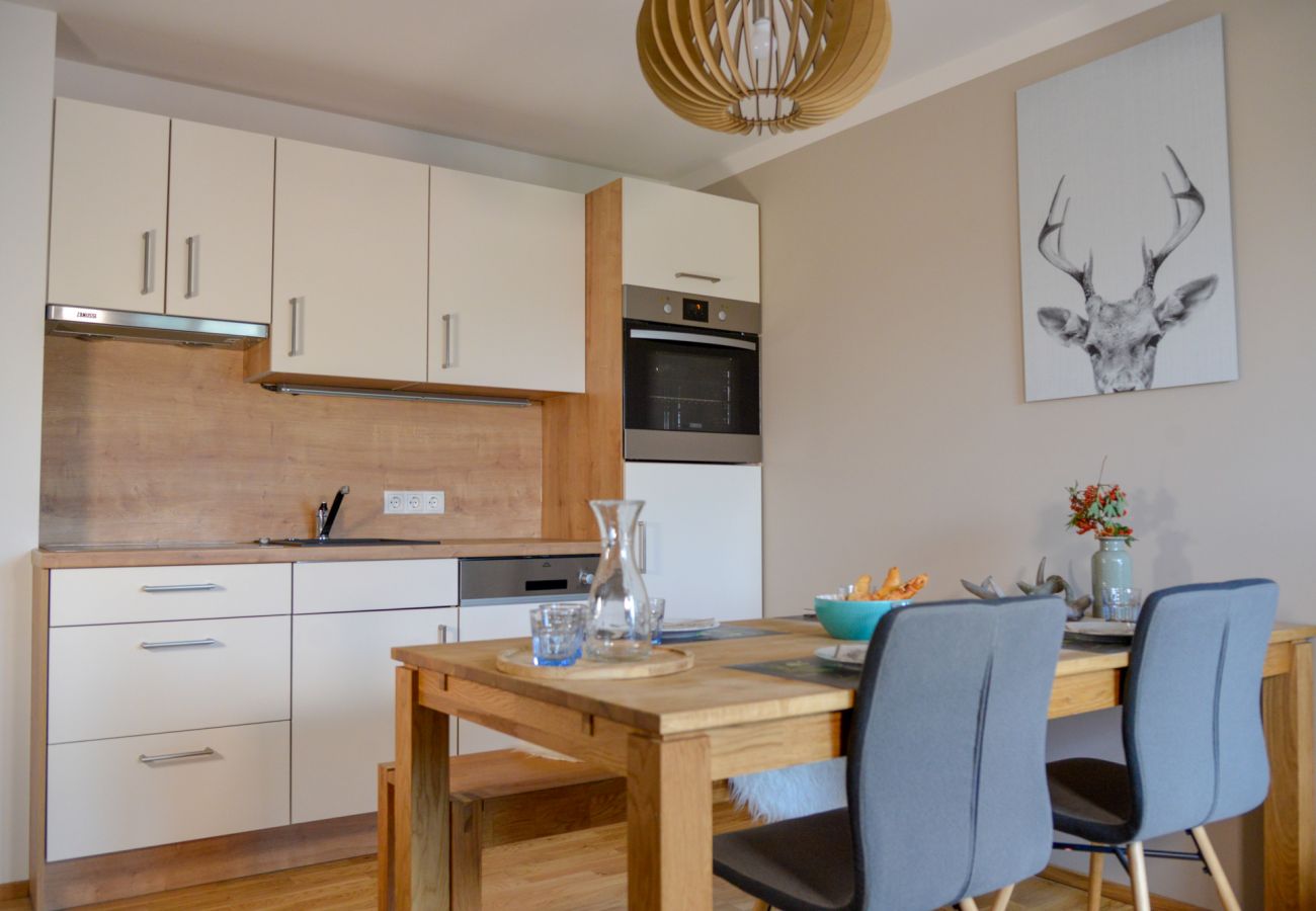 Kitchen with dining table in the holiday home Grimming Lodge Goldrute in Tauplitz