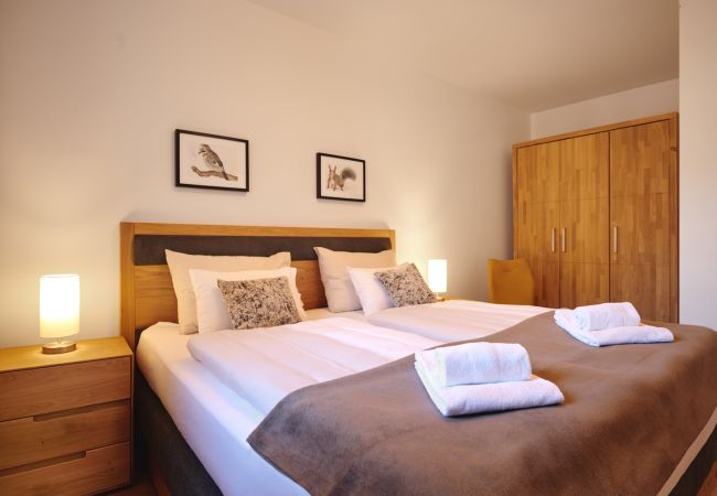 Schlafzimmer 2 mit Kleiderschrank und Sessel in der Ferienwohnung Alm Lodge A5 in Tauplitz