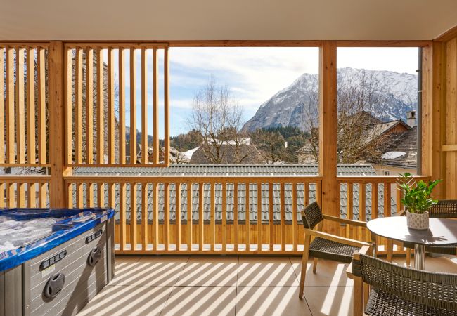 Balkon mit Whirlpool und Aussicht auf die Berge in der Ferienwohnung Alm Lodge A3 in Tauplitz