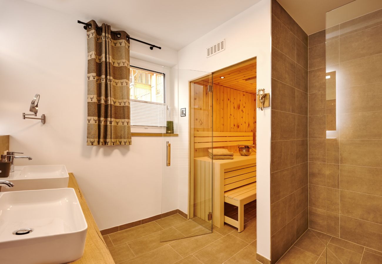 Badezimmer mit Regendusche sowie Sauna in der Ferienwohnung Adler Auszeit Lodge D6 in Tauplitz