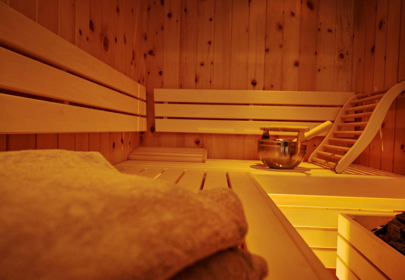 Badezimmer mit Regendusche, Fenster sowie Sauna in der Ferienwohnung Adler Lodge D6 in Tauplitz