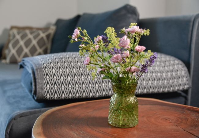 Wohnzimmertisch mit Blumen in der Ferienwohnung Grimming Lodge Goldrute in Tauplitz